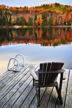 Wooden dock with chair on calm fall lake