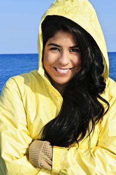 Portrait of beautiful smiling brunette girl wearing yellow raincoat