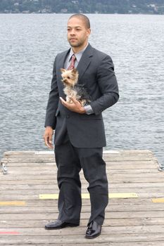 Ethnic Business Man and Yorkshire Terrier Dog at lake. Corporate Executive's best friend. 