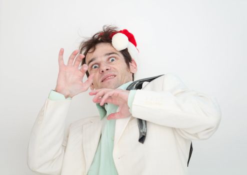 The amusing man in a white suit and christmas cap is frightened