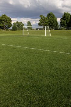 A view of a net on a vacant soccer pitch.
