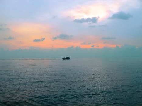 Single ship sailing on silent sea. Sunset.