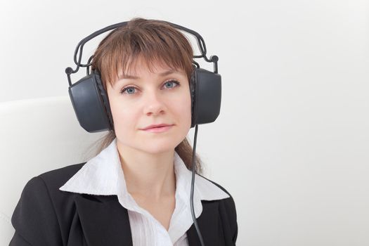 Portrait of the young woman with the big ear-phones on a head