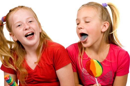 two young girls are showing their blue tongue after licking lollypop on white