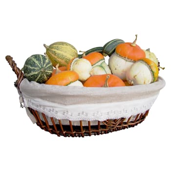 Ornamental pumpkins in autumn wicker basket, object isolated