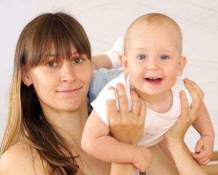 Mother and the child are engaged with the instructor in a sports hall