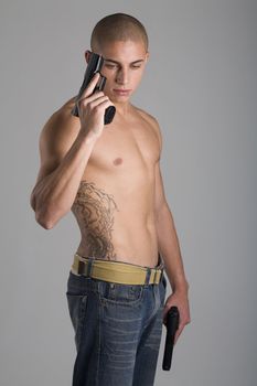 A young, muscular brazilian man in a studio shot on a gray background.