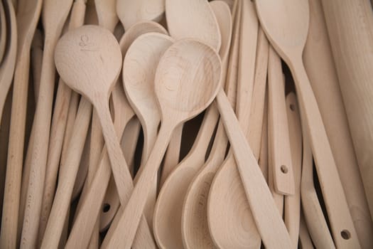 Group of wooden cooking spoons on stall.