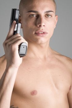 A young, muscular brazilian man in a studio shot on a gray background.