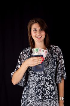 Smiling World traveller with three different currencies in her passport