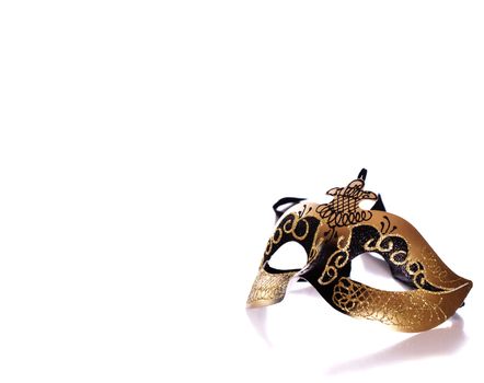 A fancy venetian mask shot against a white background with part of it's reflection in front