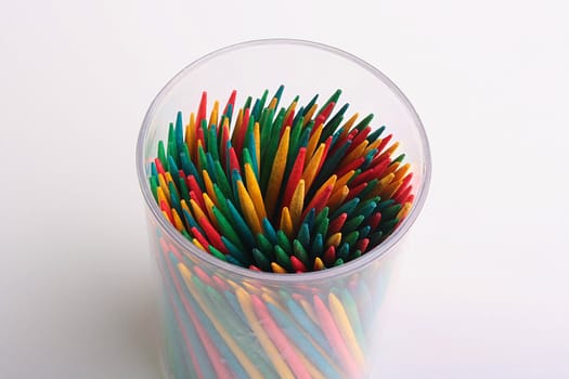 Set of colour toothpicks in plastic glass.