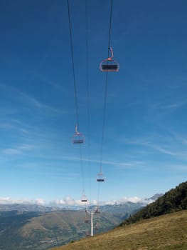  Empty ski lifts during the summer with pyrenees mountains in the background