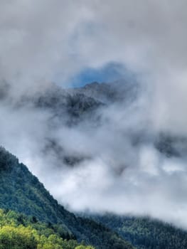 Pyrenees mountains range in fog with forest on the foreground  hdr processed