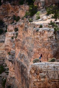 Man standing on a rocky outcropping in the Grand Canyon