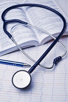 stethoscope, medical book, pen and electroencephalogram in blue