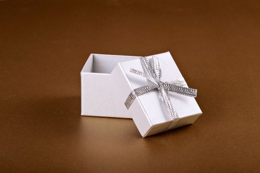 christmas gift with decorative ribbon on gold background