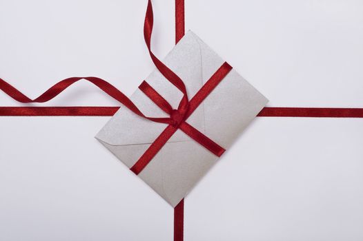 christmas envelope with red ribbon on white background