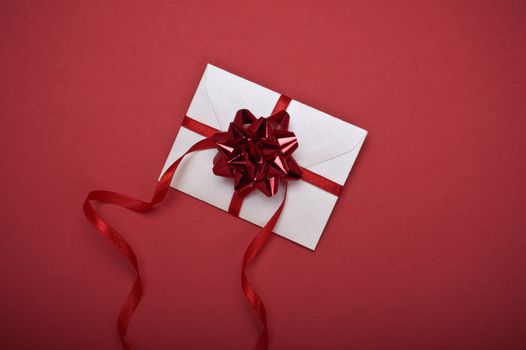 christmas envelope with decorative ribbon on red background