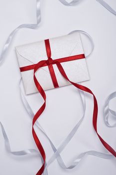christmas envelope with red and silver ribbon on white background