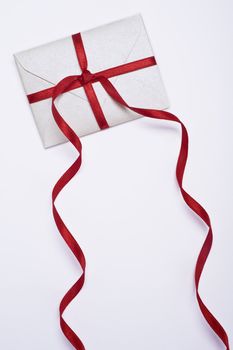 christmas envelope with red ribbon on white background