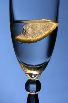 Lemon in glass with mineral water