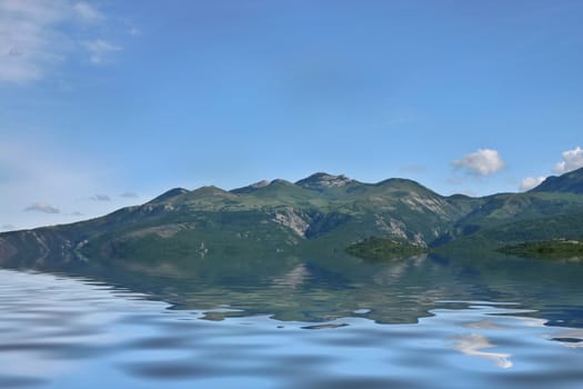 Green mountain slopes with reflection