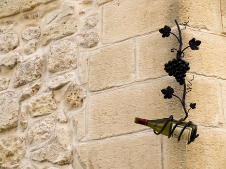 Bottle of wine hanging on old medieval wall