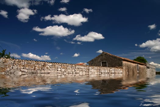 Old house with beautiful clouds and reflection in water