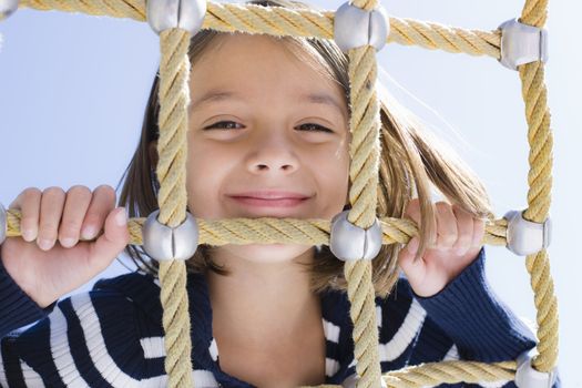 Young Girl Lying on Stomach Looking Through Hammock