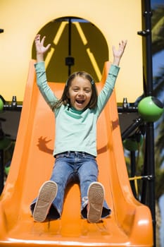 Smiling Young Girl in Park on a Slide