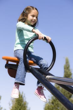 Young Girl in Park Sitting on a Seesaw
