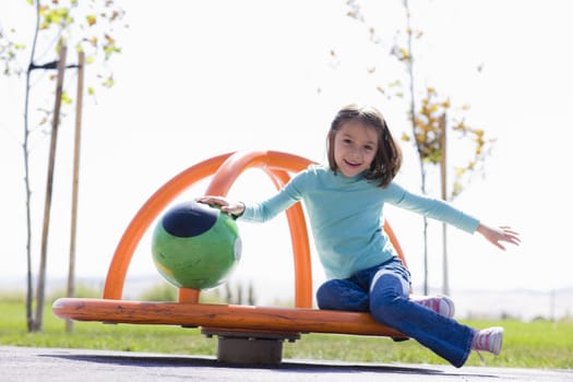 Young Girl Spinning in Playground in a Park