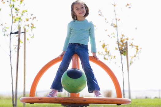 Young Girl Spinning in Playground in a Park