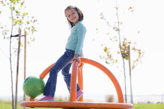 Young Girl Spinning in Playground in a Park