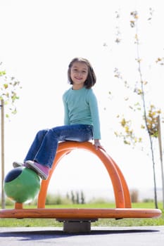 Young Girl Spinning in Playground in a Park