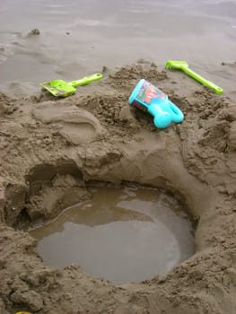           A pit made by some children in the sand of the beach.