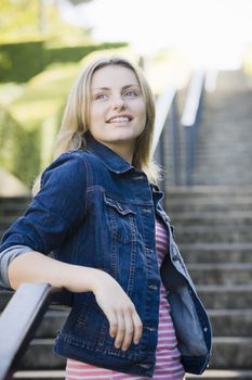 Pretty Blonde Teen Girl Standing at Bottom of  Stairway