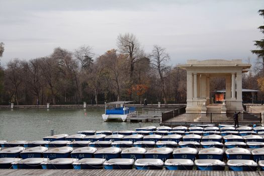 Rowing boats for hiring out on the lake of Retiro Gardens in a cloudy  winter morning in Madrid.