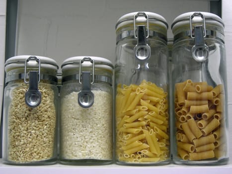 Some jars containing several kinds of rice and pasta.