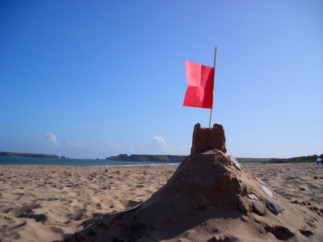 A sand castle on South Beach at Tenby with Caldey Island in the distance.