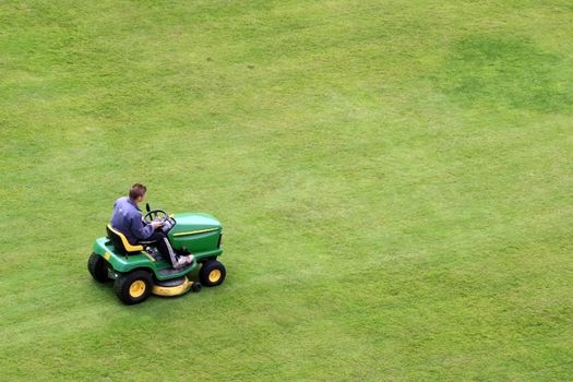 Lawnmower removing the grass on Pembroke Castle yard.