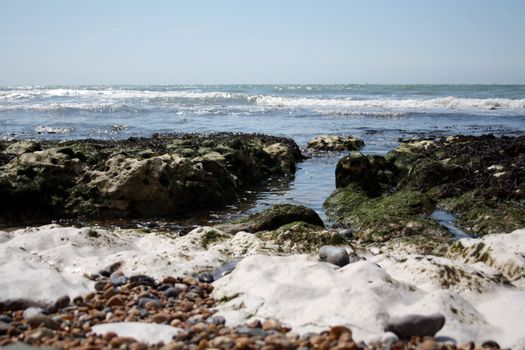 Many kind of rocks and pebbles appears when tide is low close to cliffs in La Marina at Brighton.