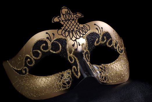 An intricate venetian mask, shot against a black background