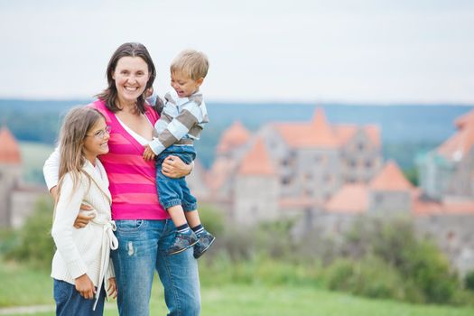 Travelers. Young mother with her two children on a tour of European medieval castles.