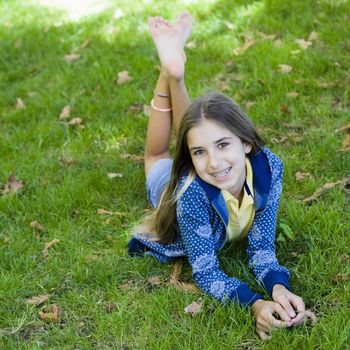 Portrait of Smiling Tween Girl lying On Grass Smiling To Camera