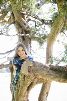 Portrait of Smiling Tween Girl Standing in a Tree