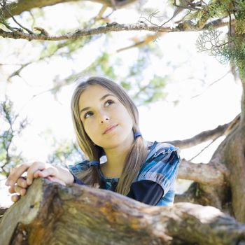 Portrait of Smiling Tween Girl Standing in Tree