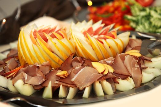 parma ham with melon and salad at the buffet -close-up