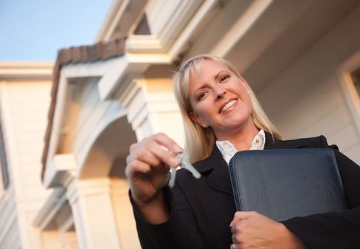 Female Real Estate Agent Handing Over Keys in Front of Beautiful House.